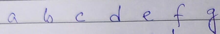 A ruled line reading a b c d e f g in blue ballpoint, every letter standing clear of the next.