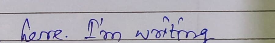 A ruled line from the same page reading here. I'm writing, in joined-up blue ballpoint.